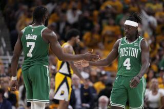 Boston Celtics guard Jrue Holiday (4) celebrates with teammate guard Jaylen Brown.