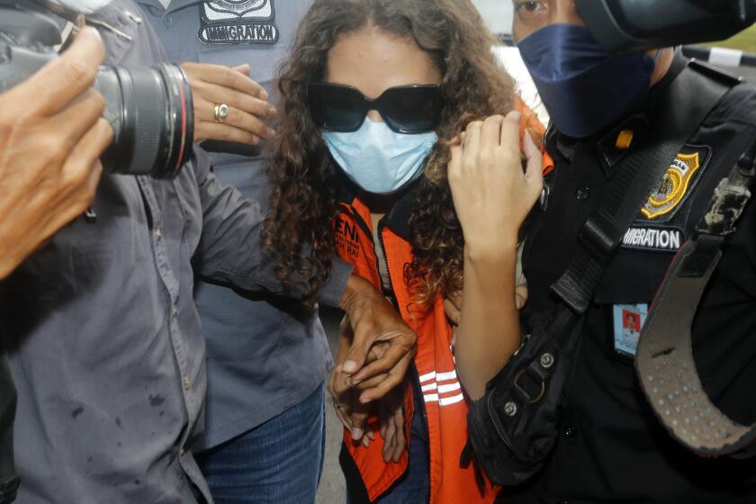 Heather Mack of Chicago, Ill., center, escorted by Indonesian immigration officers to Immigration detention center in Jimbaran, Bali, Indonesia on Friday, Oct. 29, 2021. The American woman convicted of helping to kill her mother on Indonesia's tourist island of Bali in 2014 walked free from prison Friday after serving seven years of a 10-year sentence and will be deported to the United States. (AP Photo/Firdia Lisnawati)
