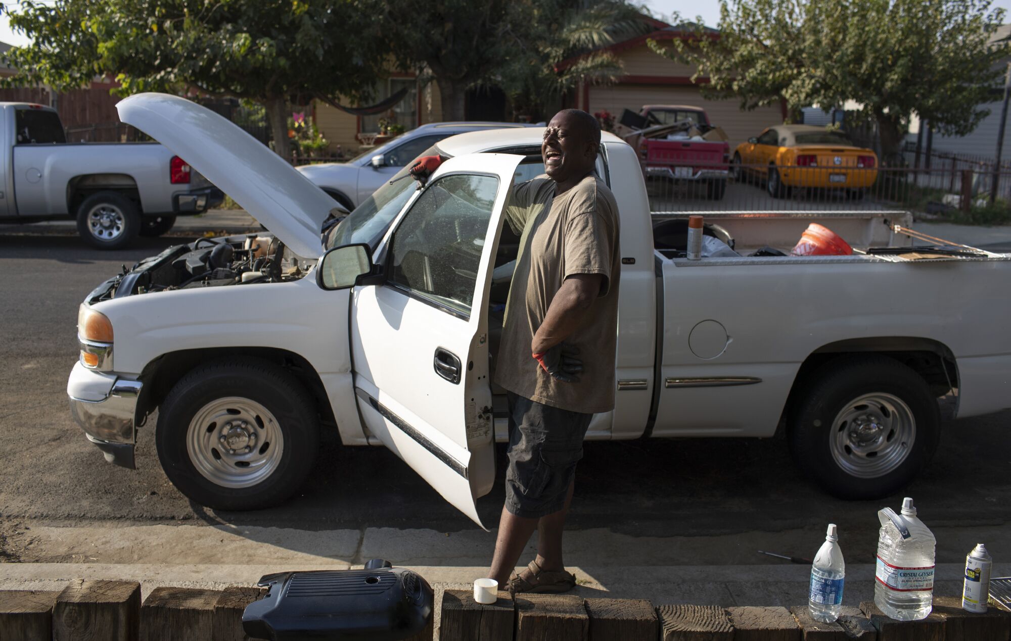 New resident Gailton Moore spends his time refurbishing a pickup truck in front of his home in Stratford.