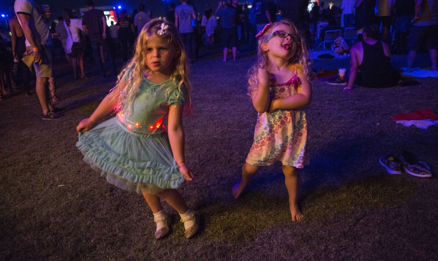 Rhya, 5, left, and Saydee, 3, right, Provensen of Huntington Beach dance to Neil Young.