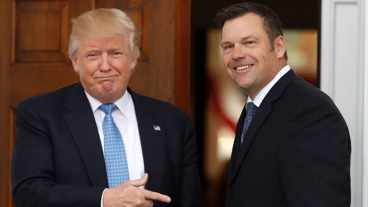 President-elect Donald Trump greets Kansas Secretary of State Kris Kobach as he arrives at the clubhouse of the Trump National Golf Club, Bedminster, in Bedminster, N.J., on Nov. 20.