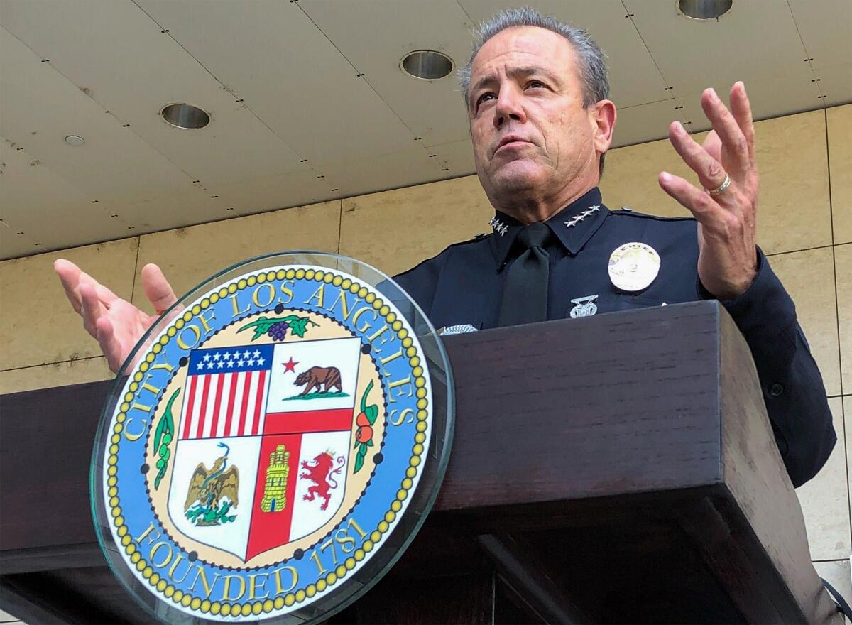 Los Angeles Police Chief Michel Moore stands at a lectern.