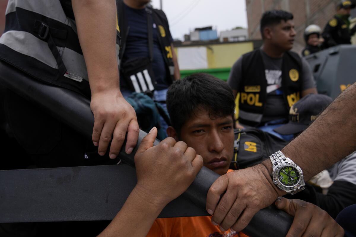 Un manifestante antigubernamental detenido se sienta en la parte trasera de una camioneta de la policía 