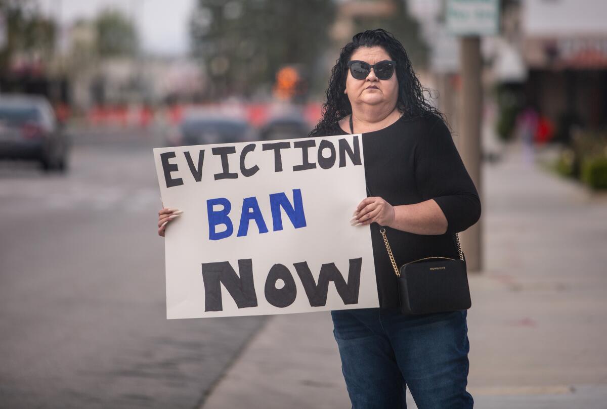 Irma Zamorano of El Monte holds a placard saying "Eviction ban now" outside El Monte City Hall 