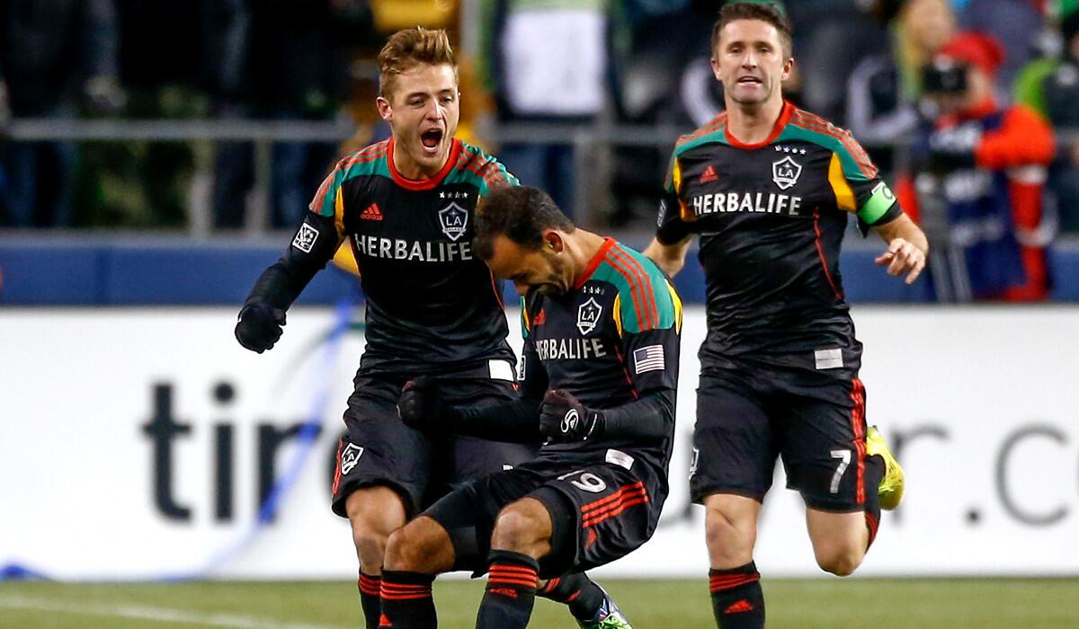 Galaxy midfielder Juninho celebrates his goal as teammates Robbie Rogers and Robbie Keane (7) join him in the second half of their game against the Sounders on Sunday in Seattle.