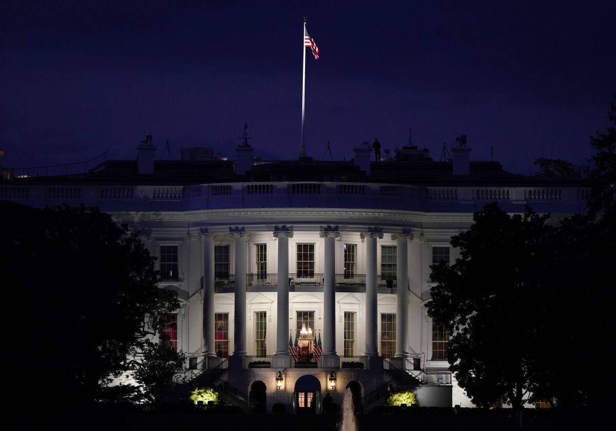 FILE - In this Oct. 5, 2020, file photo an American flag files atop the White House after President Donald Trump arrived from Walter Reed National Military Medical Center via Marine One in Washington. (AP Photo/J. Scott Applewhite, File)