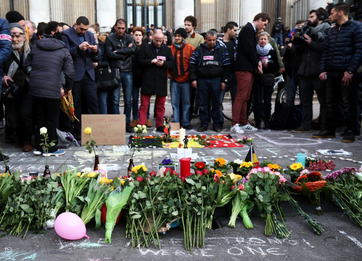 People leave tributes at the Place de la Bourse after the attacks in Brussels.