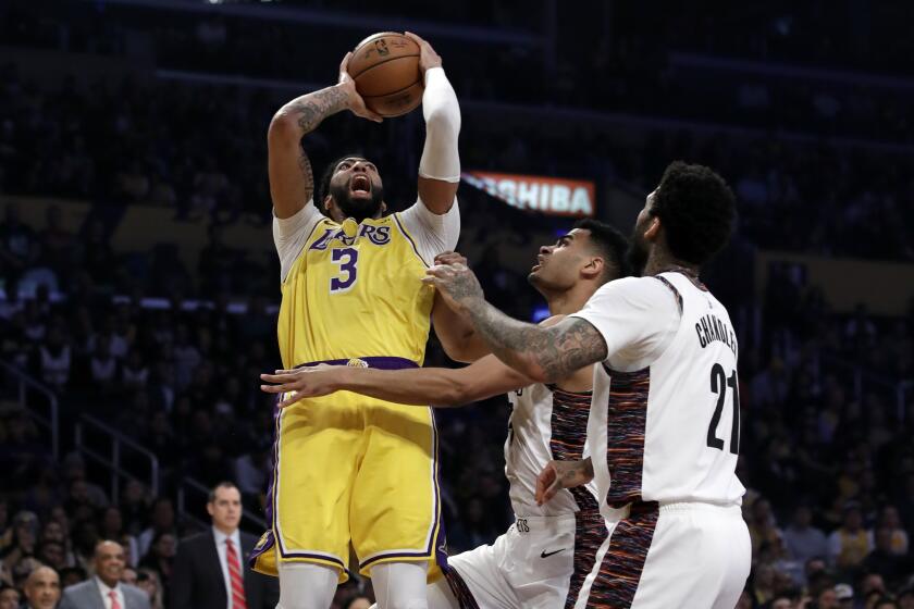 Los Angeles Lakers' Anthony Davis (3) shoots over Brooklyn Nets' Wilson Chandler (21) during the first half of an NBA basketball game Tuesday, March 10, 2020, in Los Angeles. (AP Photo/Marcio Jose Sanchez)