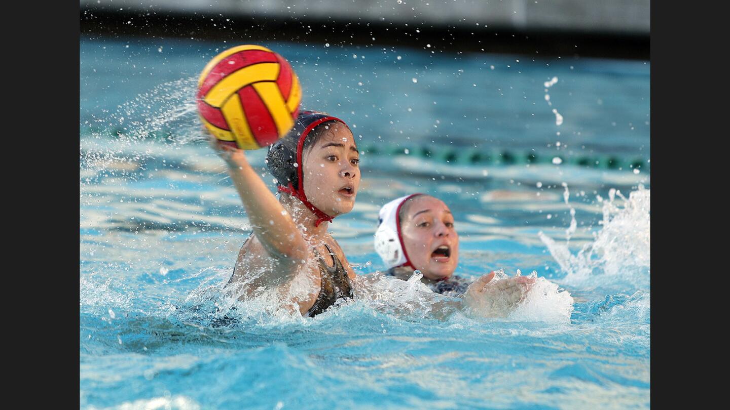 Burroughs' Gwen Turla shoots against Flintridge Sacred Heart Academy with FSHA's Lolo Monge just behind her defending in a nonleague girls' water polo match at Burroughs High School on Monday, December 4, 2017.