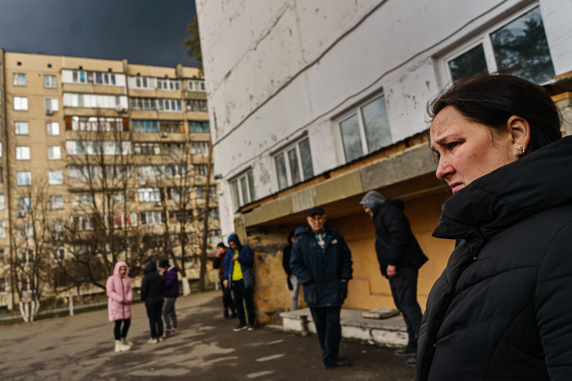 Natalia Mamalyga and others wait outside a building