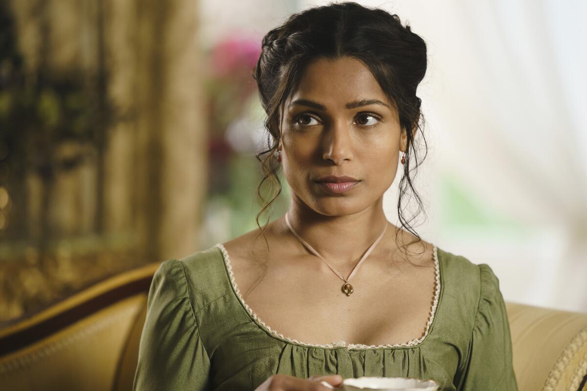 A woman in 19th-century clothing holds a tea cup in the movie "Mr. Malcolm's List."