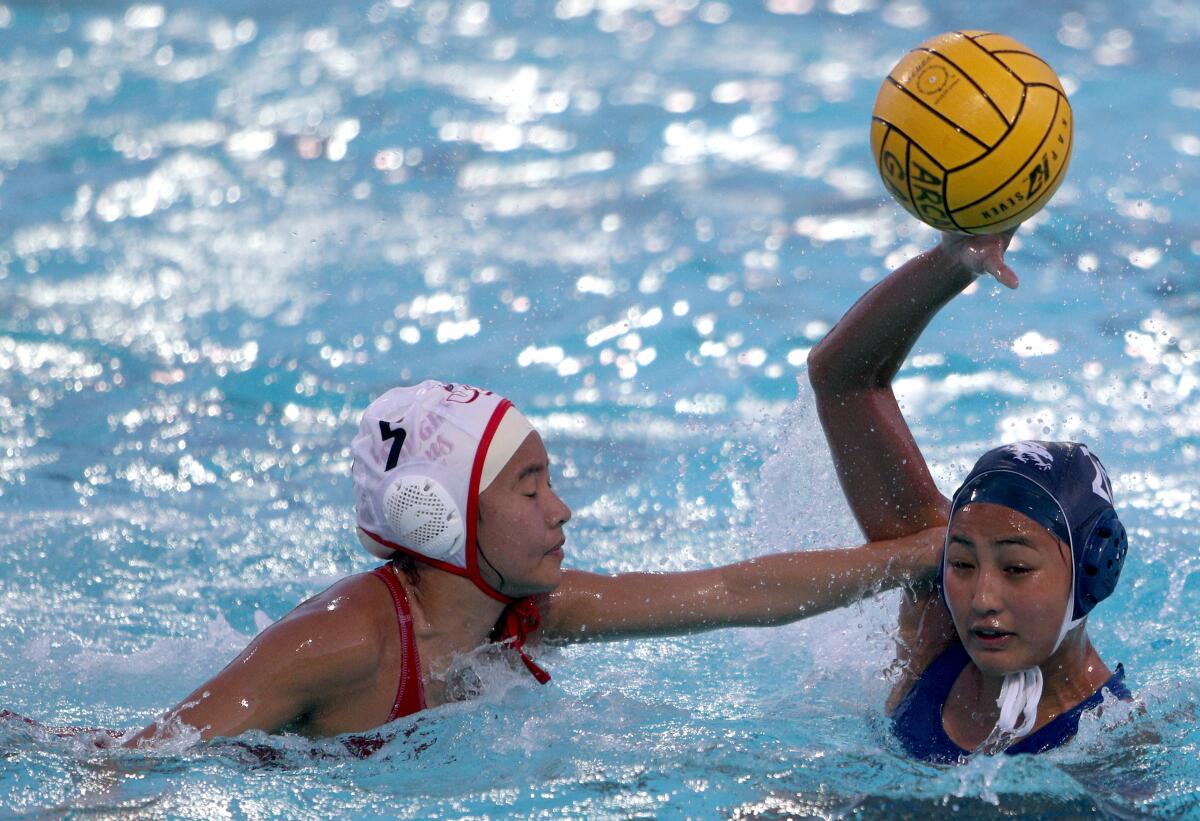 Crescenta Valley High water polo player Lexy Kawachi gets pressure from Angelina Lee, left, in the Pacific League Tournament semifinal vs. Burroughs High, at Arcadia High in Arcadia on Tuesday, Feb. 4, 2020. Burroughs won 10-3.