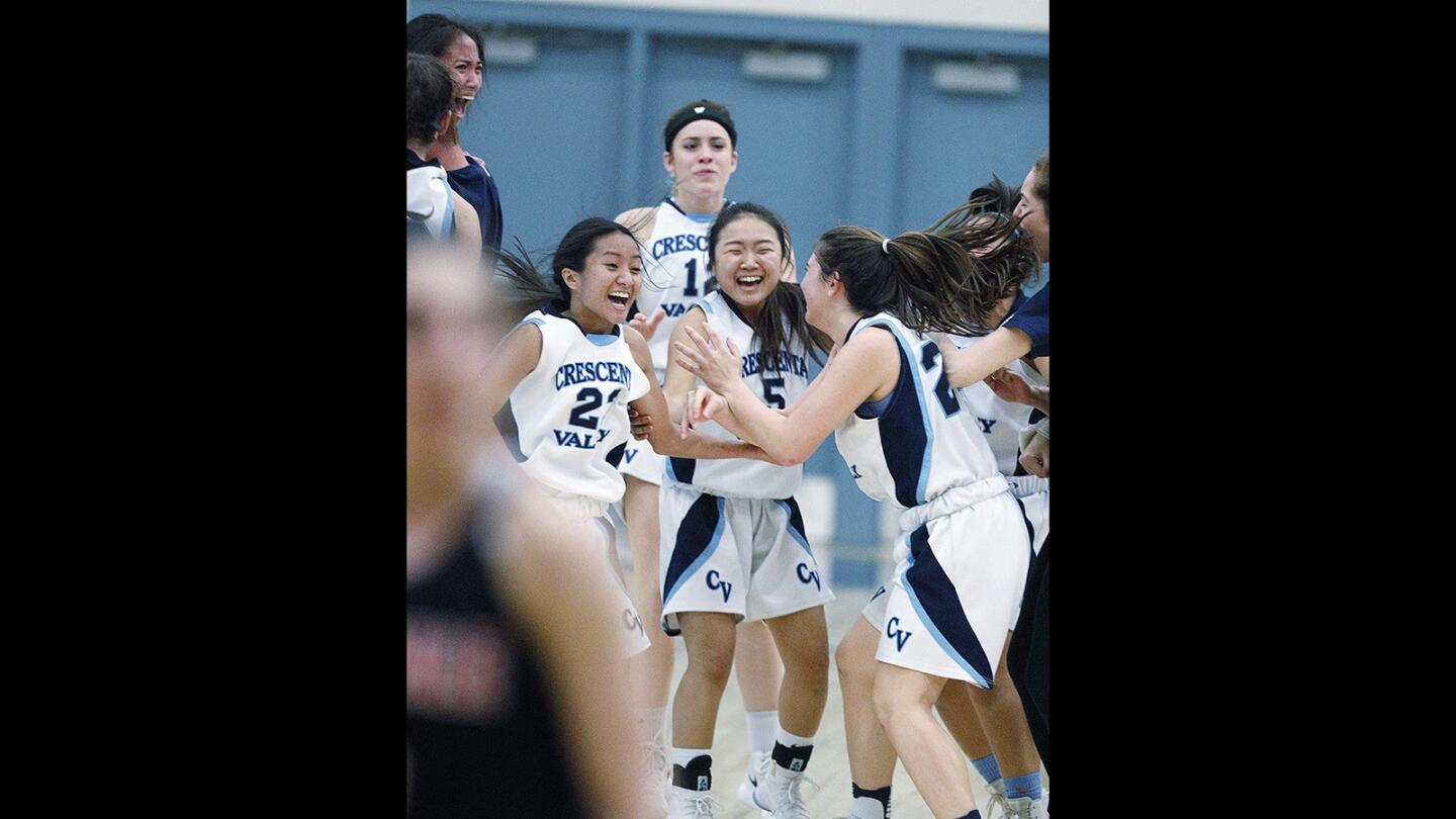 The girls of the Crescenta Valley basketball team celebrate their one-point win over league challengers Glendale in a Pacific League girls' basketball game on Monday, January 29, 2018. Crescenta Valley beat Glendale, scoring a late free throw, with a winning score of 51-50.