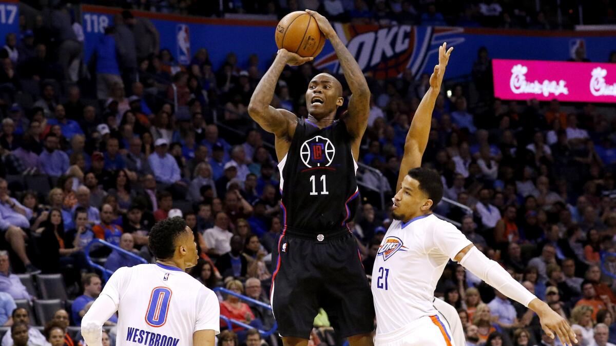 Clippers guard Jamal Crawford shoots a three-pointerl between Thunder guards Russell Westbrook (0) and Andre Roberson (21) during the first half Thursday.