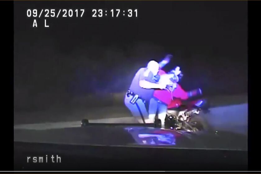 FILE - This image from the Iowa State Patrol video provided by the Cedar County Attorney's Office in Cedar County, Iowa, shows former Iowa State Patrol Trooper Robert Smith in an altercation with Bryce Yakish by Yakish's motorcycle during a traffic stop near Tipton, Iowa, in September 2017. Smith has pleaded guilty to a federal count of violating the biker’s rights, prosecutors said Wednesday, Sept. 28, 2022. (Cedar County Attorney's Office via AP, File)