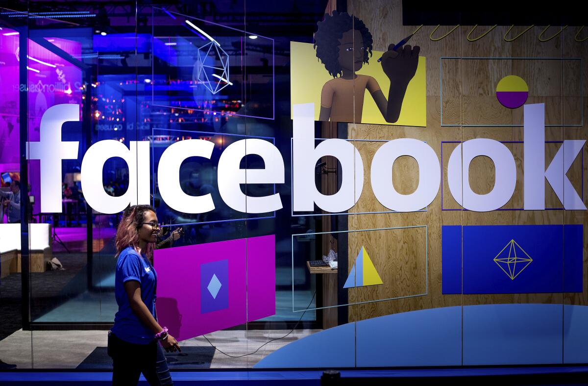 FILE - In this Tuesday, April 18, 2017, file photo, a conference worker passes a demo booth at Facebook's annual F8 developer conference, in San Jose, Calif. New York Attorney General Letitia James says a bipartisan coalition of state attorneys general is investigating Facebook for alleged antitrust issues. James said Friday, Sept. 6, 2019 the probe will look into whether Facebook's actions endangered consumer data, reduced the quality of consumers' choices or increased the price of advertising. (AP Photo/Noah Berger, File)