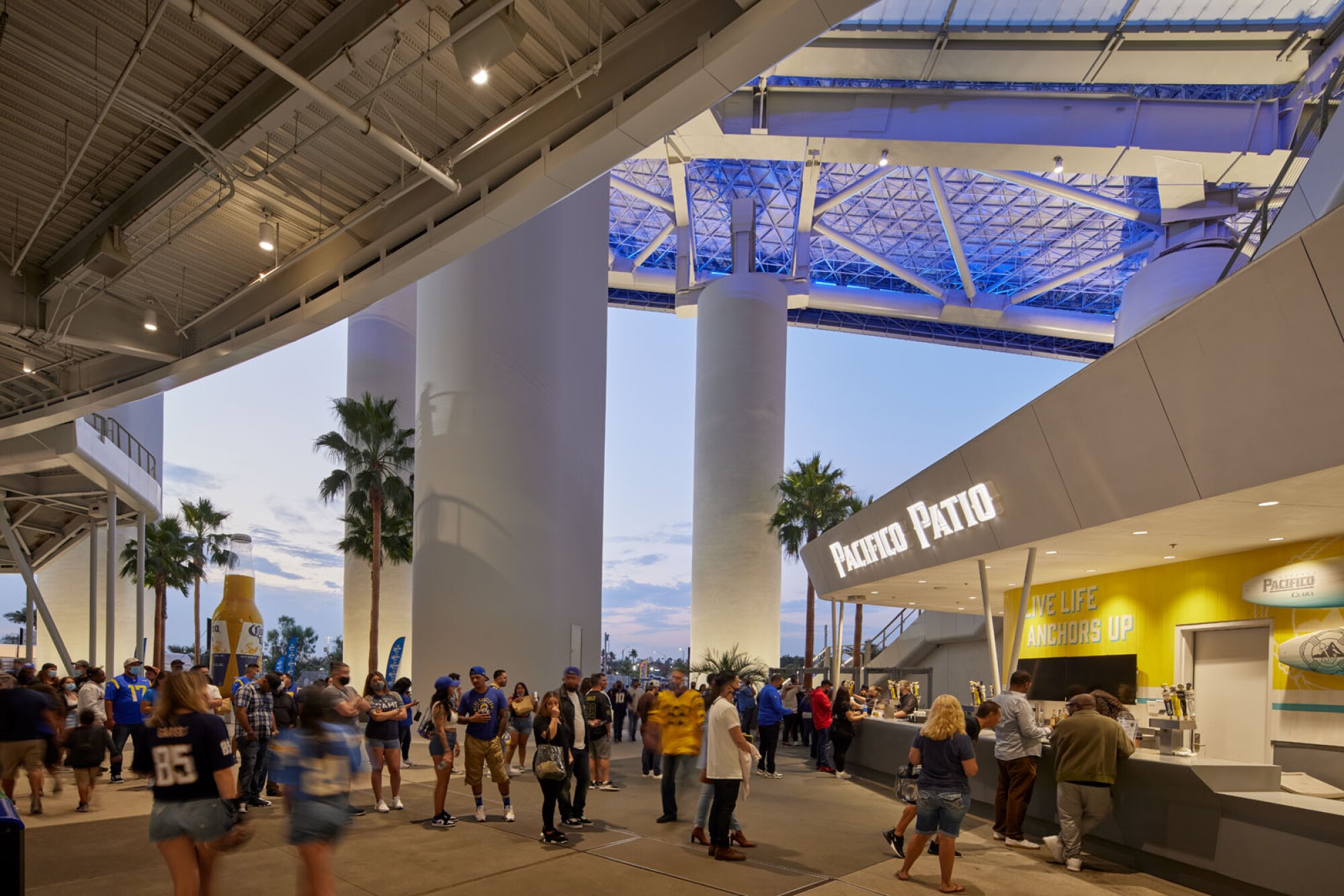 A view of an illuminated concession area on the upper concourse of SoFi at dusk.