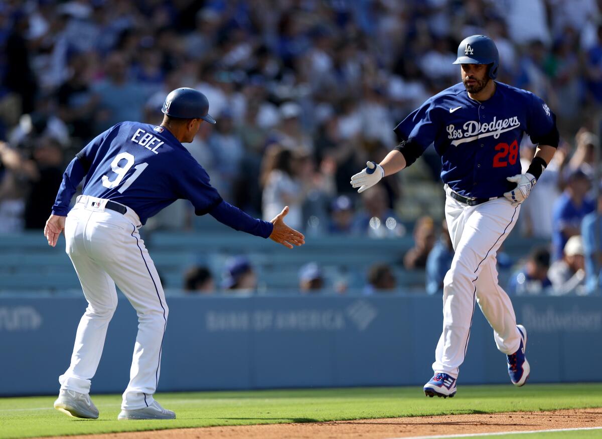 The Dodgers' J.D. Martinez is congratulated by third base coach Dino Ebel after homering May 13, 2023.