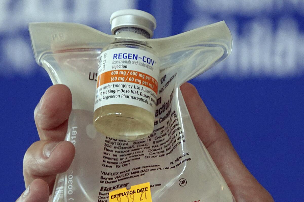 A doctor holds a Regeneron monoclonal antibody infusion bag. 