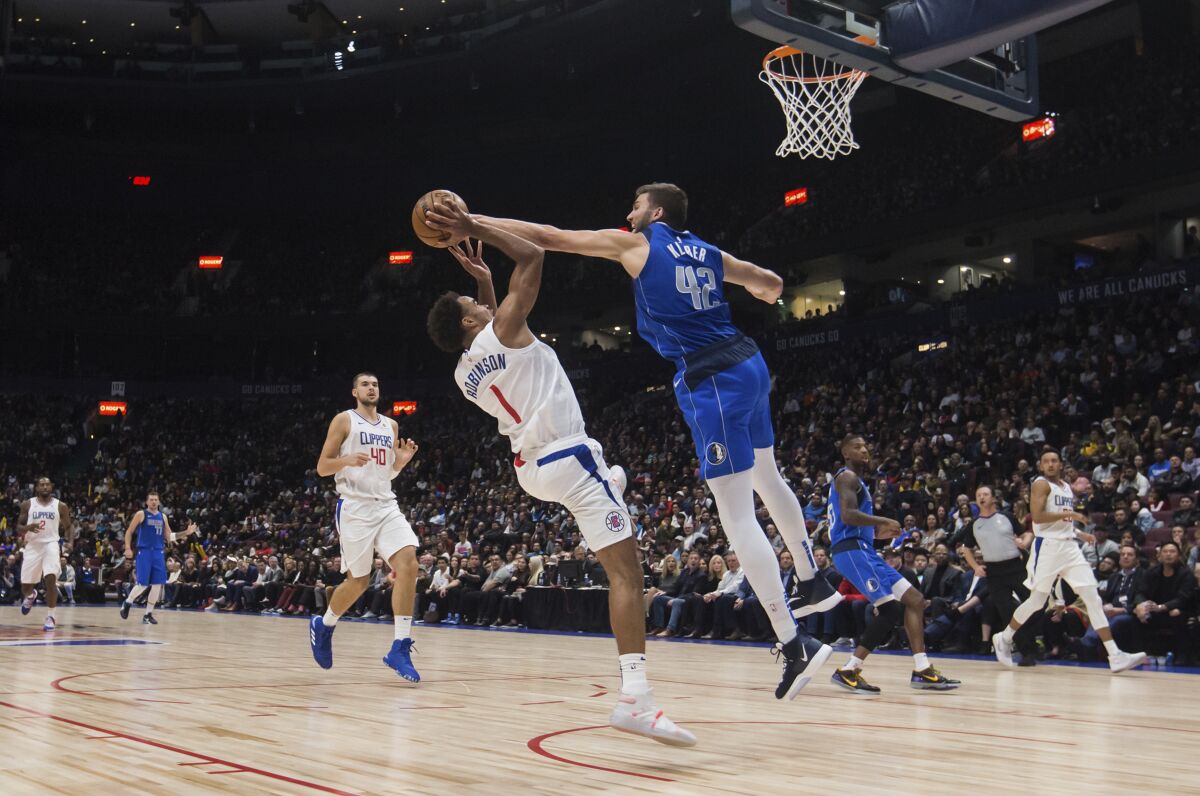Dallas Mavericks power forward Maxi Kleber blocks a shot by Clippers guard Jerome Robinson during the first half Thursday.