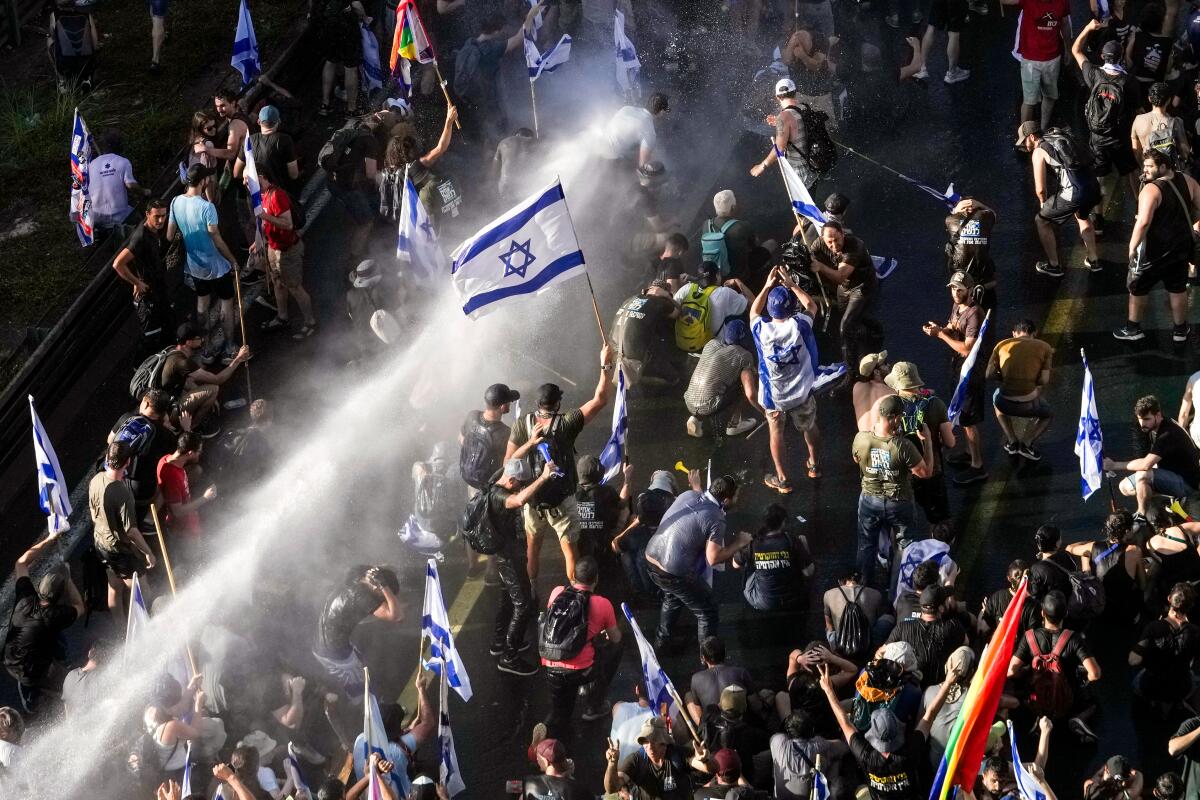 Israeli police use a water cannon to disperse demonstrators 