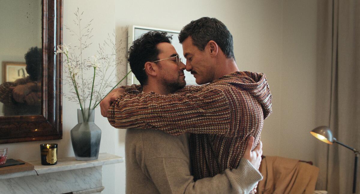 Two men embrace in their home.