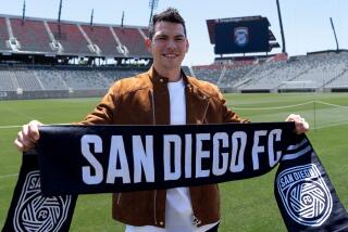 Chucky Lozano poses with a San Diego FC scarf during an introductory news conference last June.