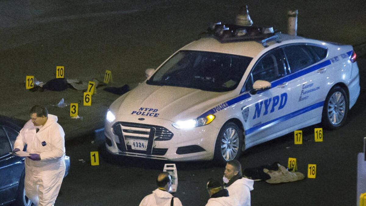 Bulletproof vests lie beside an NYPD patrol car as investigators work at the scene of two officers' fatal shootings. Authorities say the gunman acted so quickly that neither officer had time to draw his weapon.