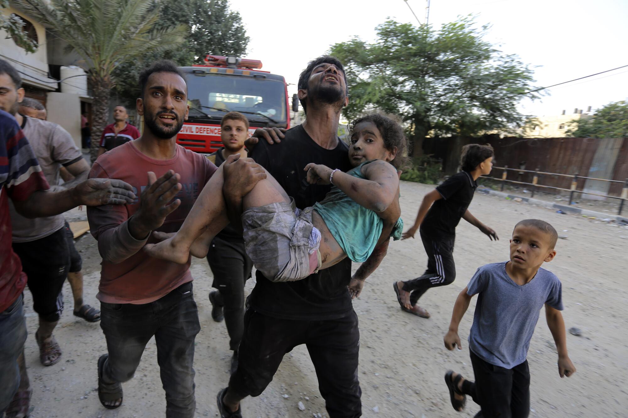 A man carries a wounded girl