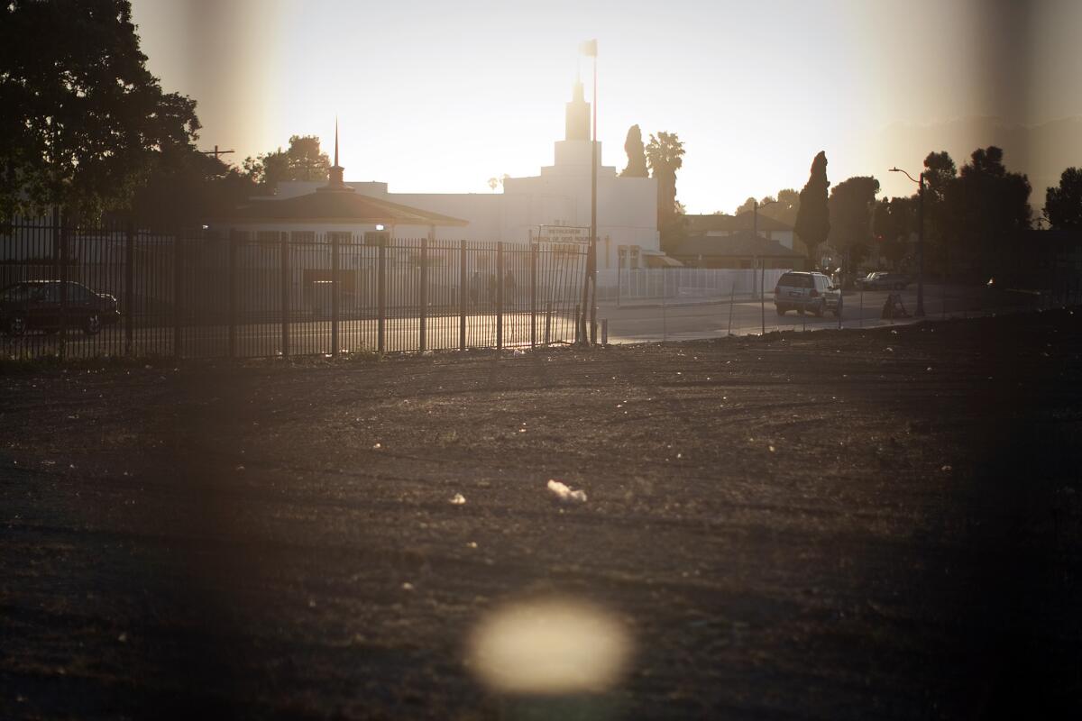 Across from the Bethlehem Church of God, a fence borders most of a vacant lot slated for redevelopment as Marlton Square at Marlton Avenue and Santa Rosalia Drive in Los Angeles.