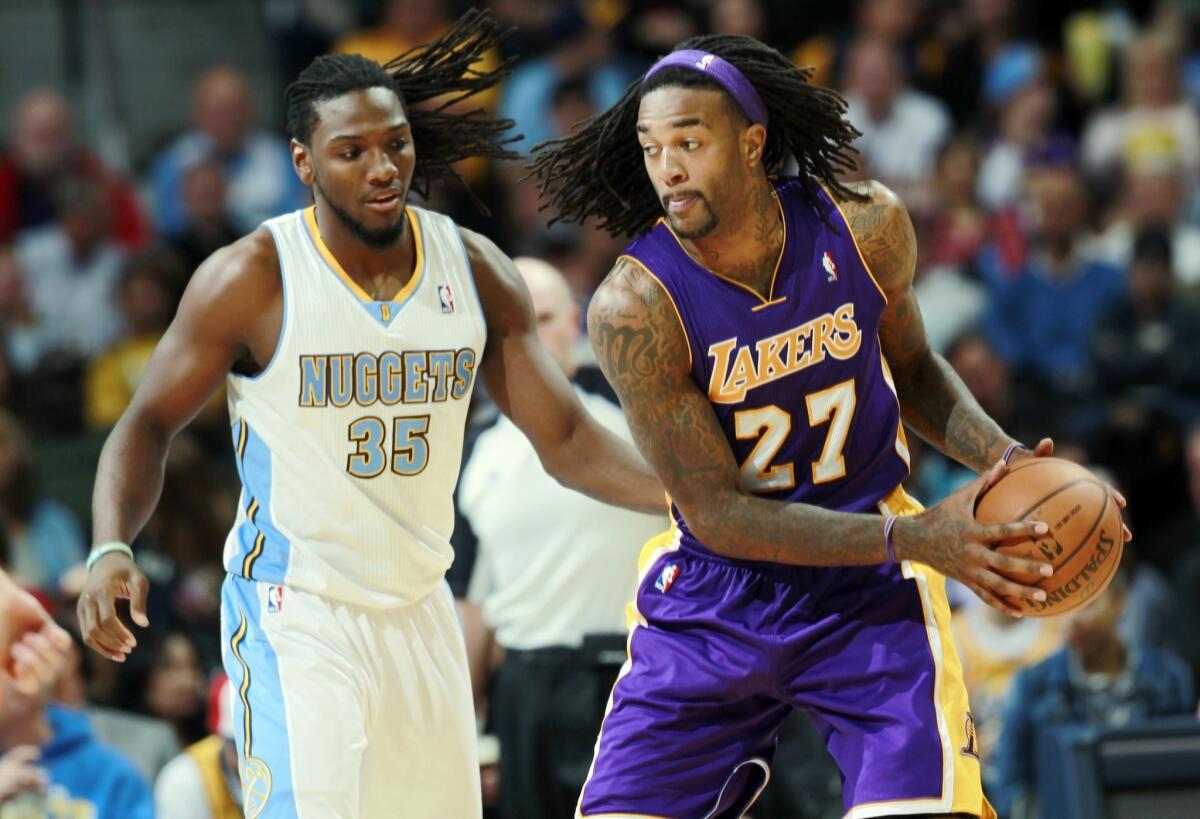 Lakers power forward Jordan Hill works in the post against Nuggets forward Kenneth Faried in the second half of the Lakers' loss Wednesday.