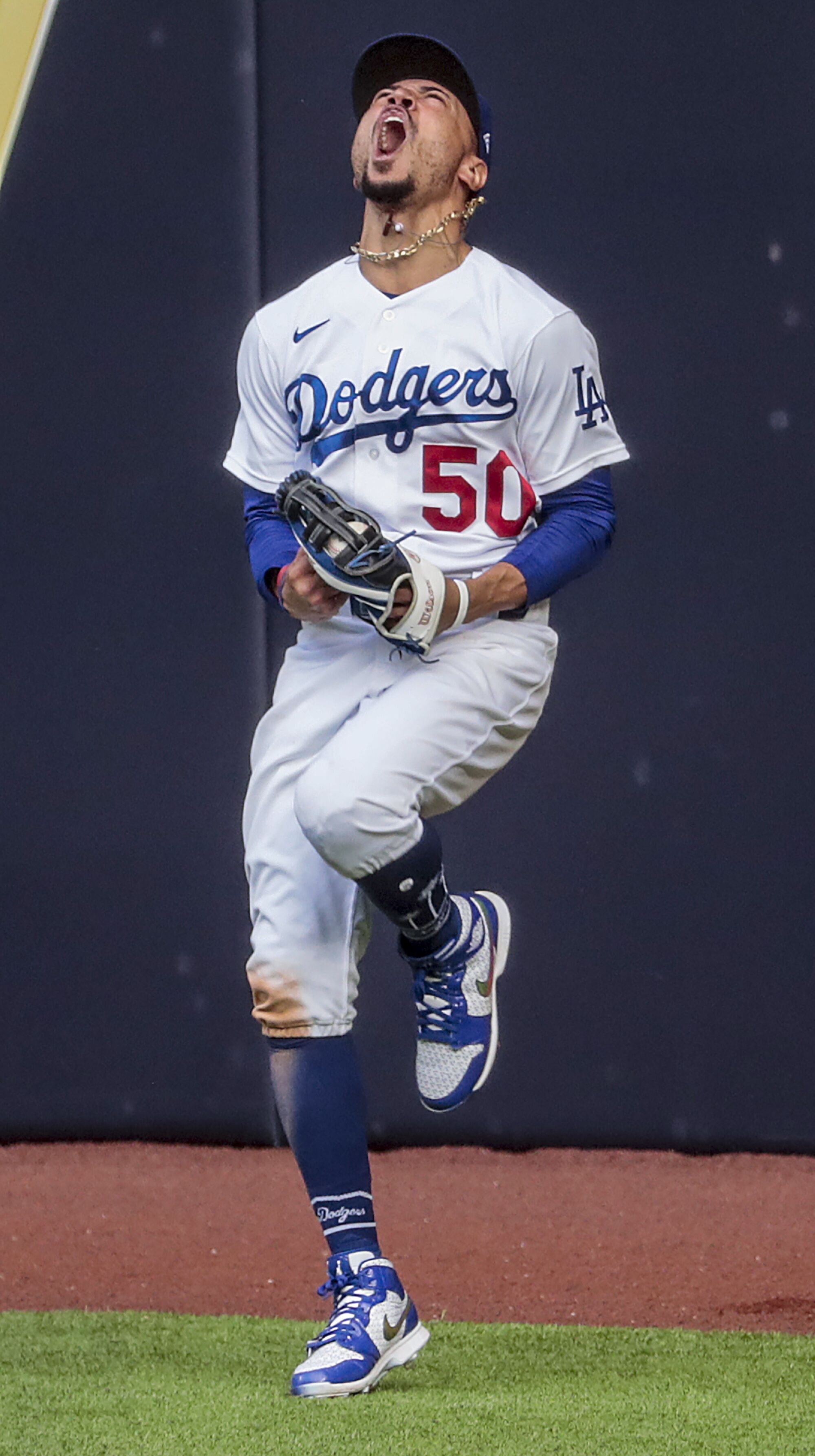 Dodgers right fielder Mookie Betts celebrates his leaping catch at the wall during the fifth inning.