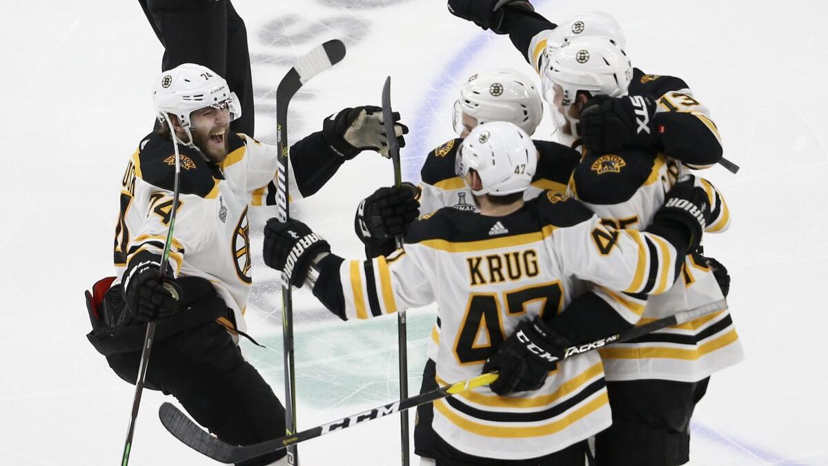 Boston Bruins left wing Jake DeBrusk (74) joins the celebration after Brandon Carlo, right, scored a goal against the St. Louis Blues during the third period.