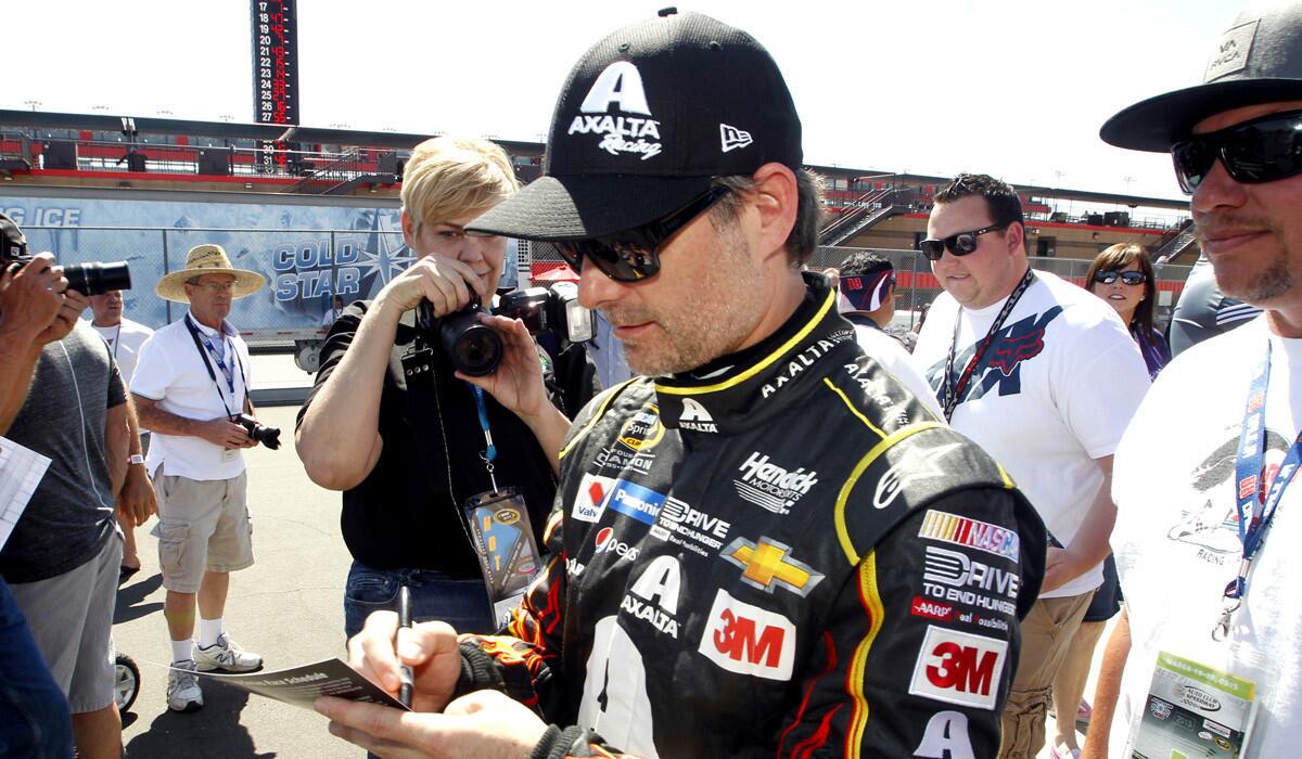 Jeff Gordon signs an autograph for a fan after a practice session to qualify for Sunday's NASCAR Sprint Cup Series auto race in Fontana on Friday.