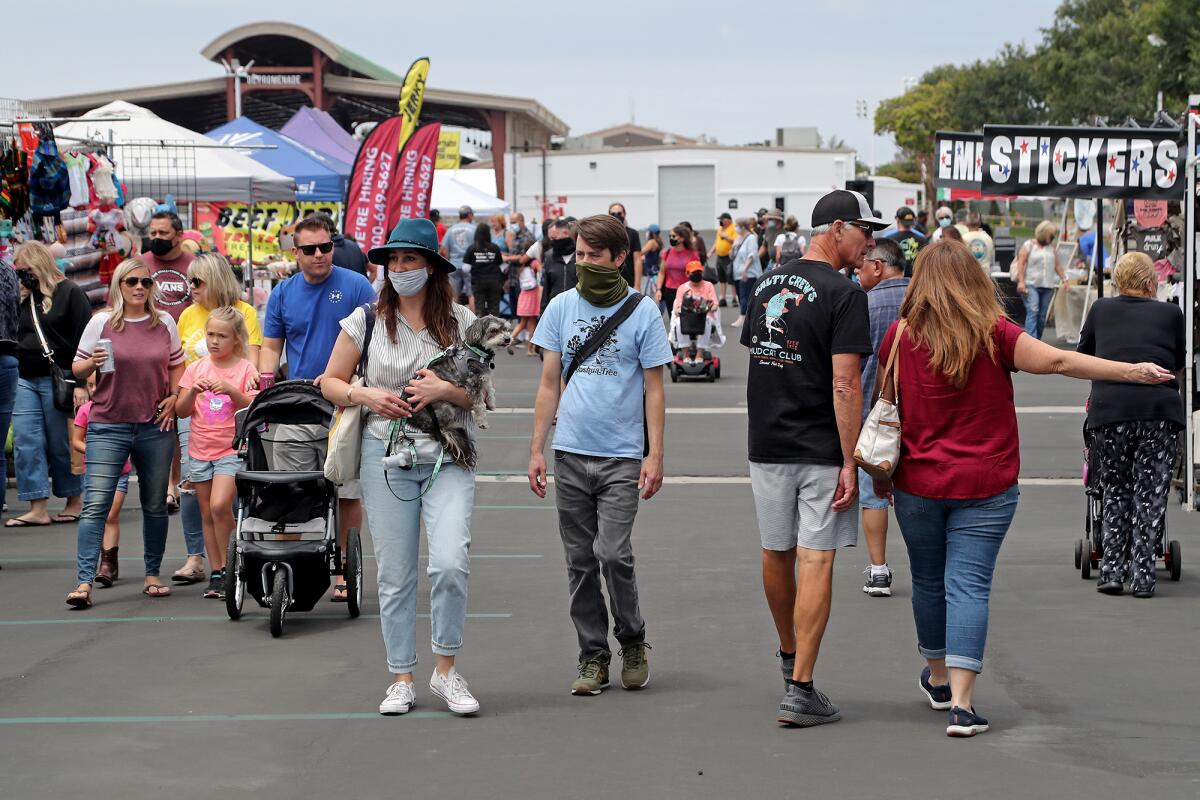 Visitors stroll through the O.C. Swap Meet at the fairgrounds in Costa Mesa on Saturday.