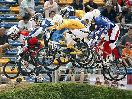 Riders race into the first set of jumps during an Olympic BMX quarterfinal qualifier at Beijing's Laoshan track.