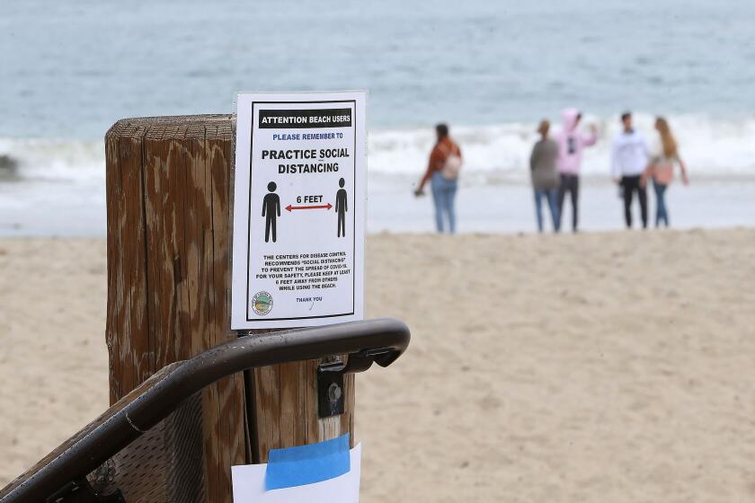 Family and friends gather on Main Beach as Laguna Beach began announced beach and park closures on Monday.