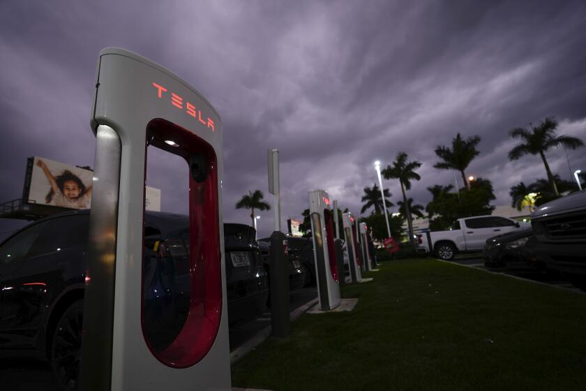 Tesla drivers charge their cars at a Tesla Supercharger station, Wednesday, Nov. 16, 2022, in Miami. (AP Photo/Rebecca Blackwell)
