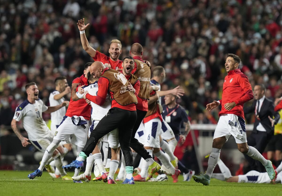 Serbian players celebrate at the end of the World Cup 2022 group A qualifying soccer match between Portugal and Serbia at the Luz stadium in Lisbon, Sunday, Nov 14, 2021. (AP Photo/Armando Franca)
