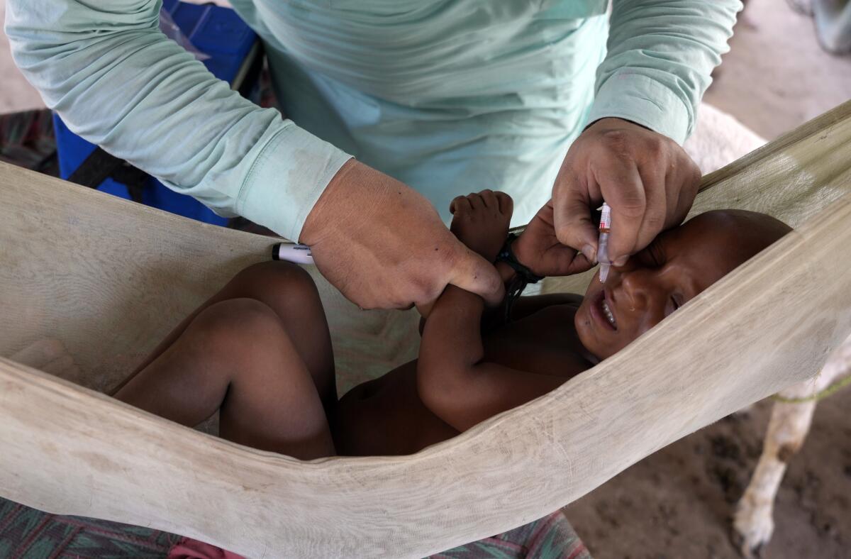 A health worker administers a polio vaccine to a child in a neighborhood of Lahore, Pakistan, Monday, June 3, 2024. (AP Photo/K.M. Chaudary)