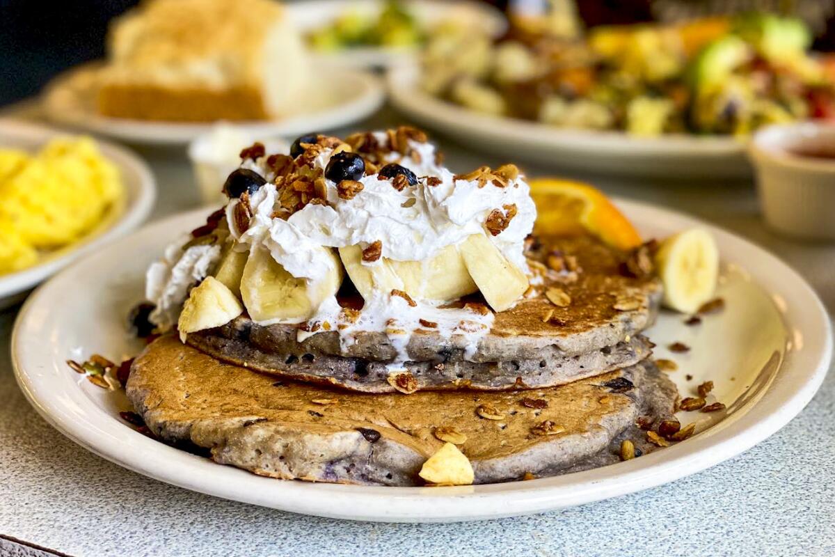 Blueberry pancakes topped with bananas and whipped cream