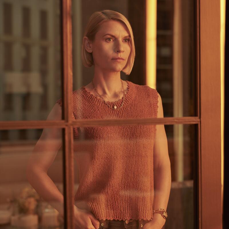 A woman in pink sleeveless top is seen through a window.