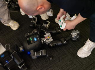 David Zhang, CEO at High Torque, a robotics company from China, troubleshoots Pi Plus on the floor of the exhibition hall.