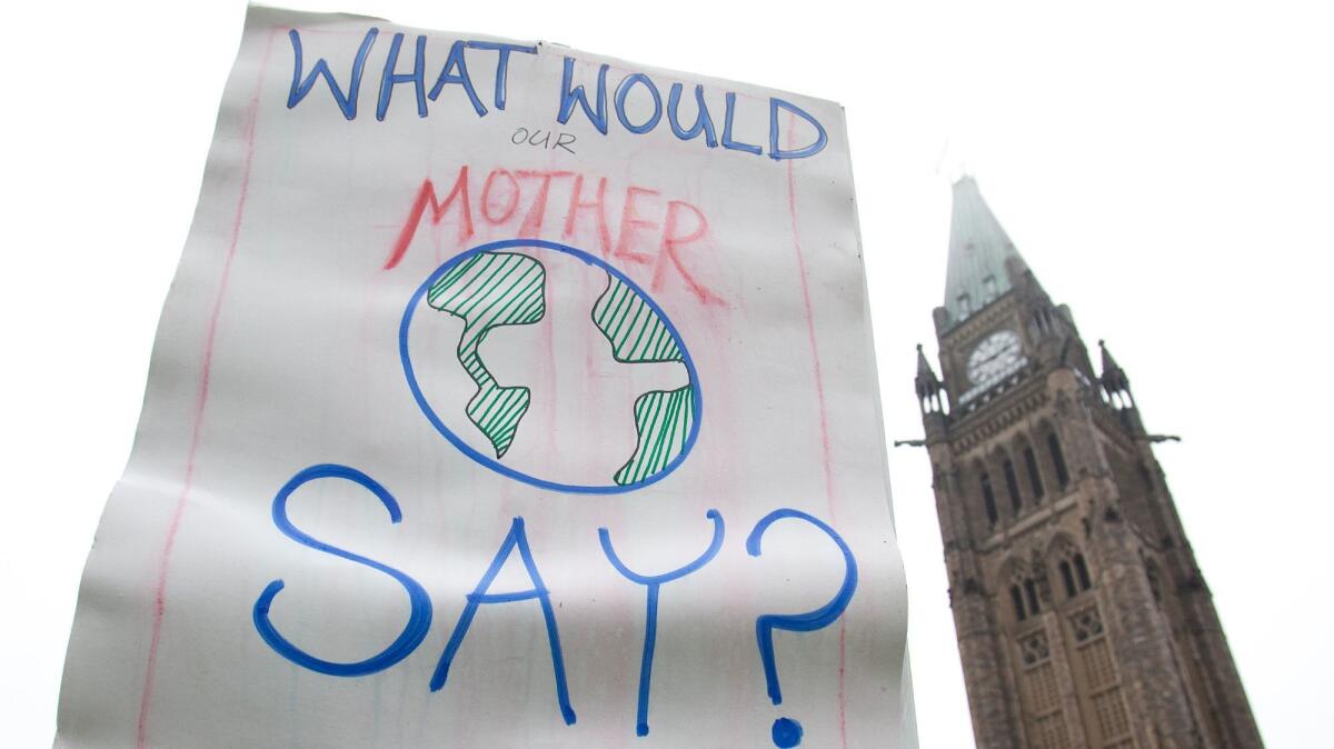 A demonstrator holds up a sign in protest over a lack of action on climate change.