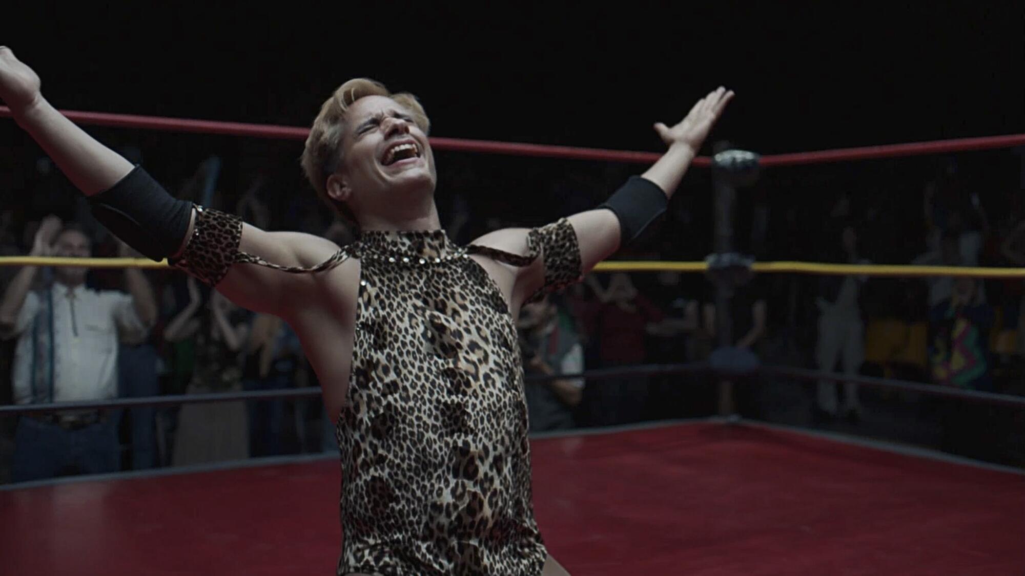 A wrestler smiles and laughs at the crowd.