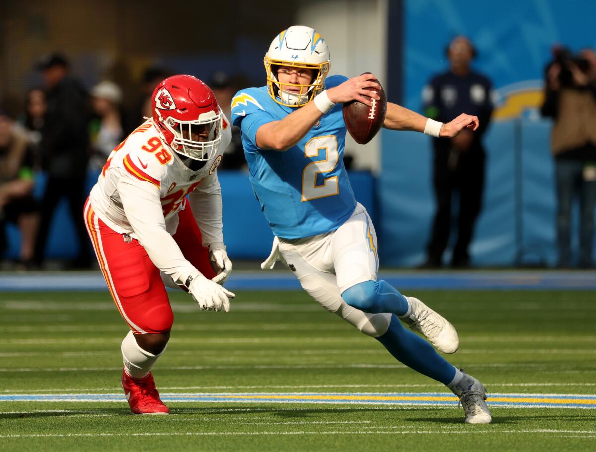 Chargers quarterback Easton Stick tries to scramble away from Chiefs defensive end Tershawn Wharton.