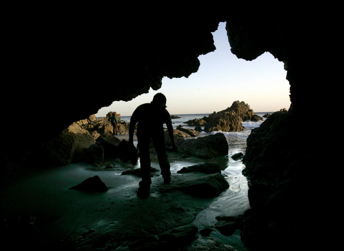 Greg Wood, 25 of Northridge, enters a cave on the beach at Leo Carillo State Park in Malibu.
