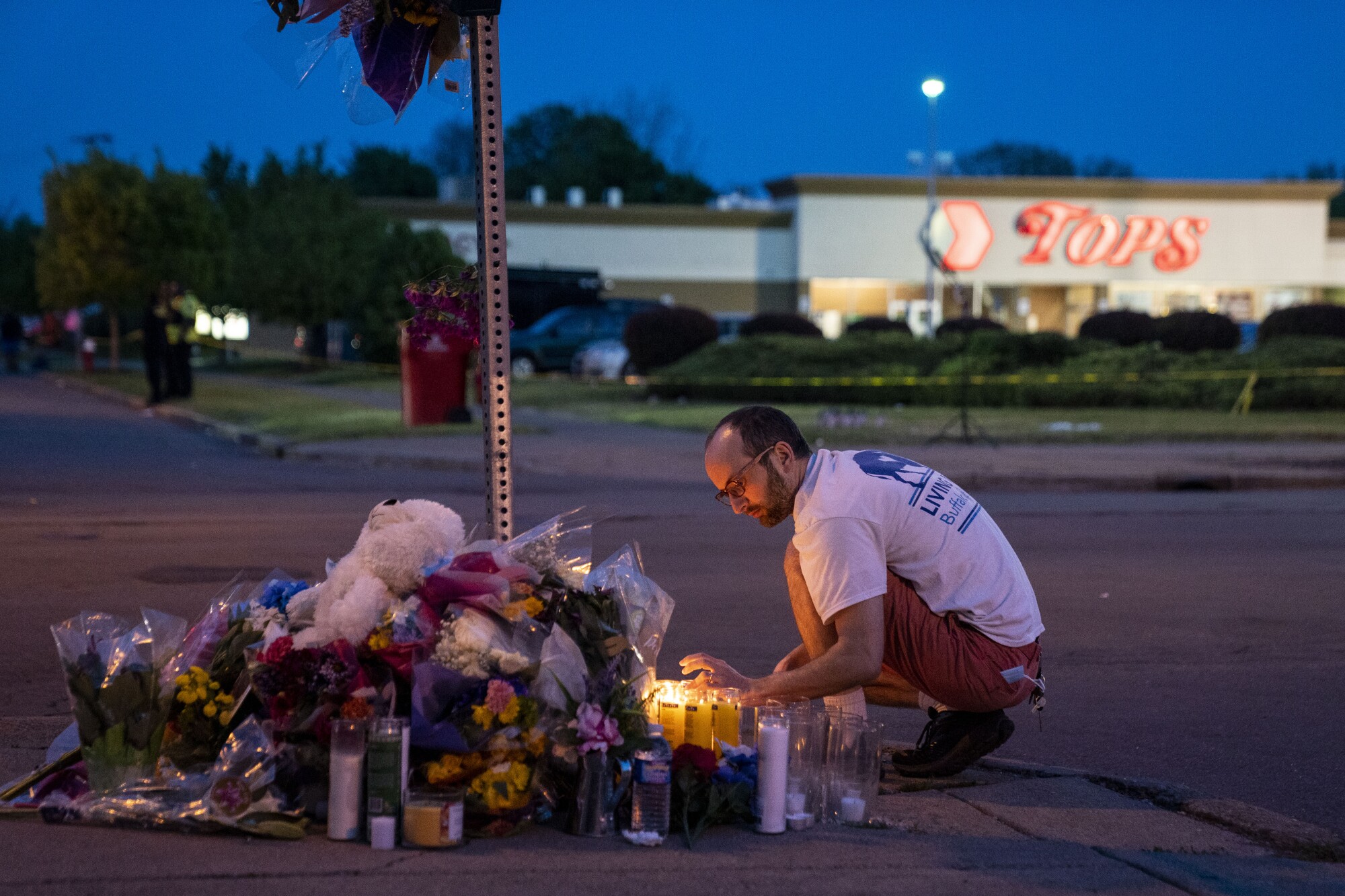 Timothy Kujawski of Buffalo lights candles at a makeshift memorial