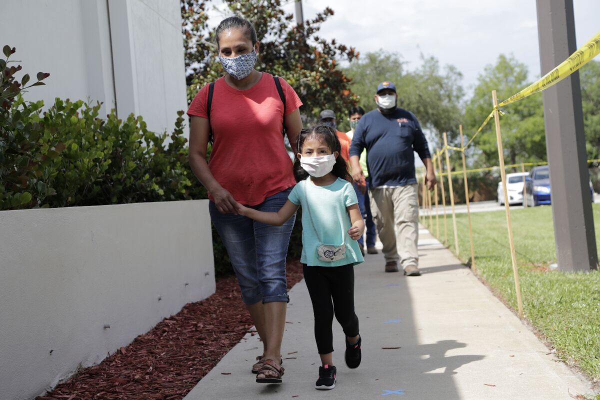 Flora Garcia arrives with her daughter Krislaya Trejo at the Florida Department of Health in Collier County