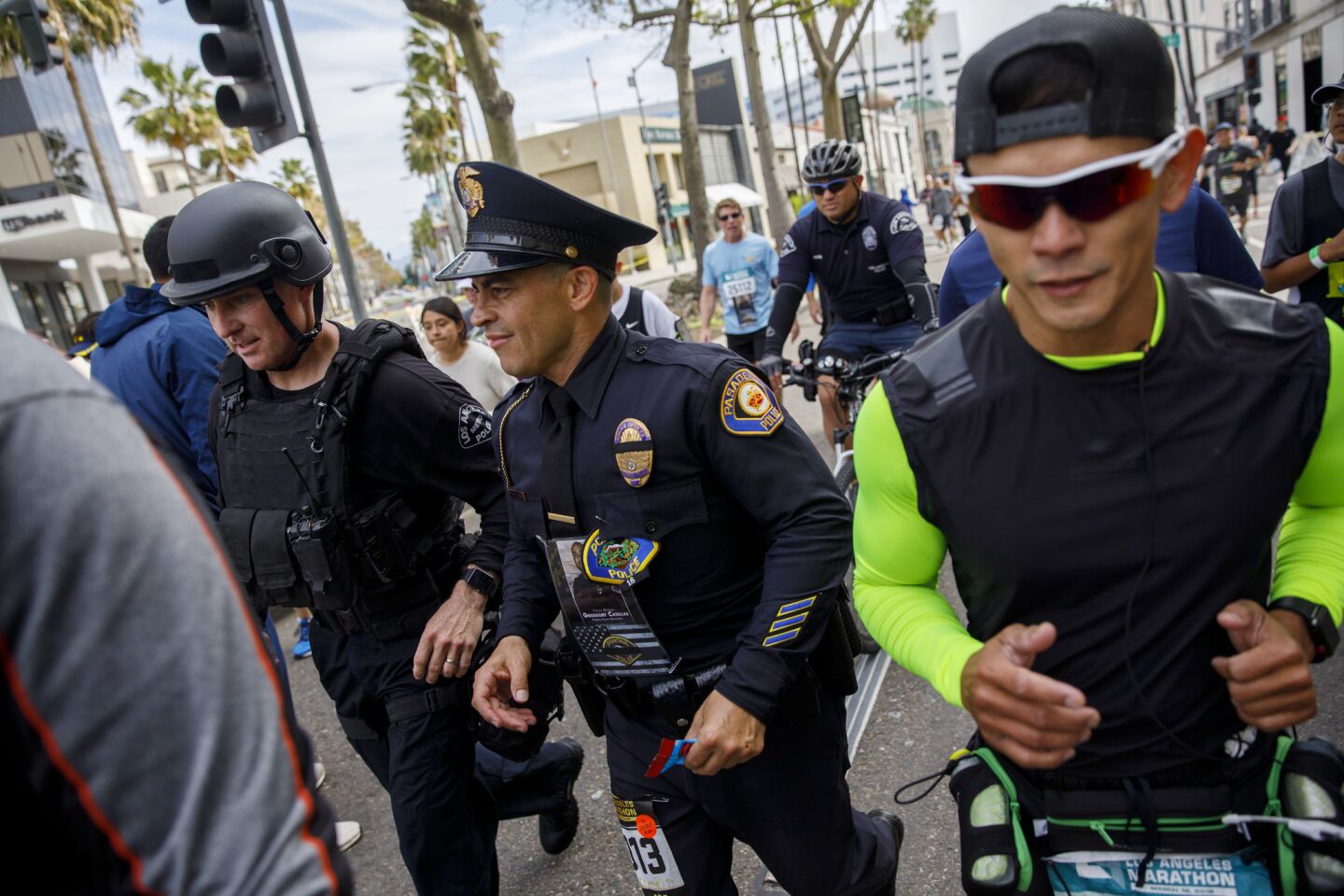 Police officers run in full uniform and tactical gear past mile 17in the L.A. Marathon in Beverly Hills.